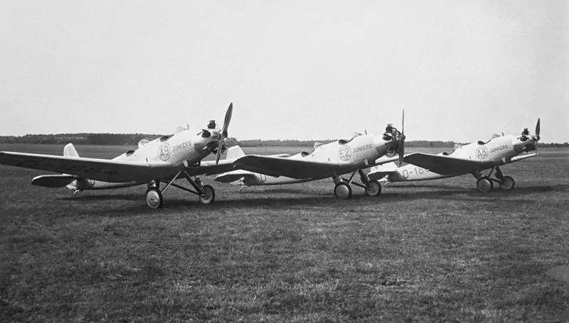 Eine historische Aufnahme von 3 Junkers A50 Flugzeugen auf einer Wiese