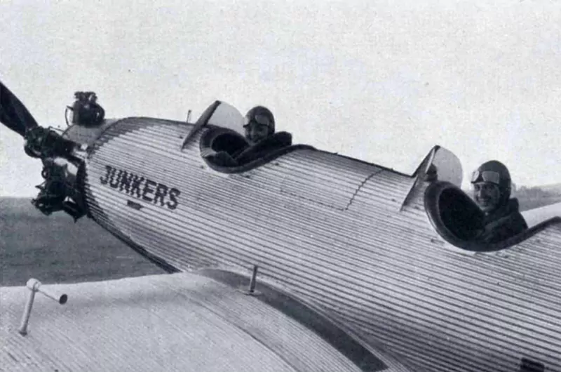 Eine historische Aufnahme von zwei Piloten, die in einem Junkers A50 Junior Flugzeug sitzen.