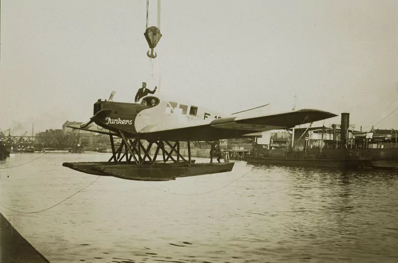 Eine historische Aufnahme eines Junkers F13 Wasserflugzeugs, wie es grade ins Wasser abgelassen wird