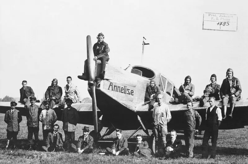 Eine historische Aufnahme eines Junkers F13 Flugzeugs mit einer Versammlung an Piloten drumherum